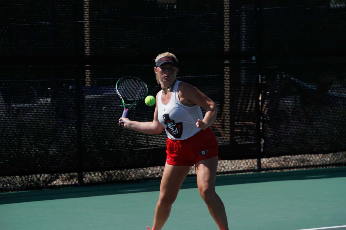 Ana Albertson getting ready to hit the incoming tennis ball. 
Photo by: Joann Morales