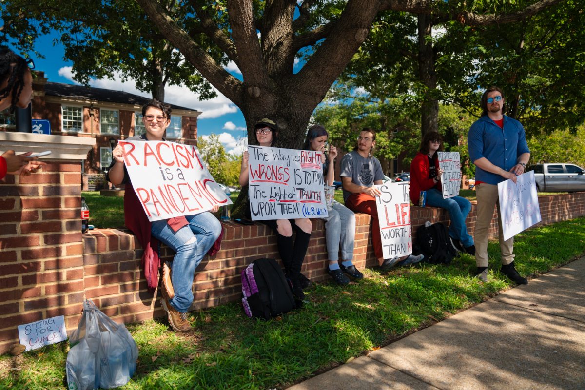 APSU students hold signs in front of Clement Building on Sept. 20 in protest of newly hired assistant professor being allegedly involved with extremist groups.