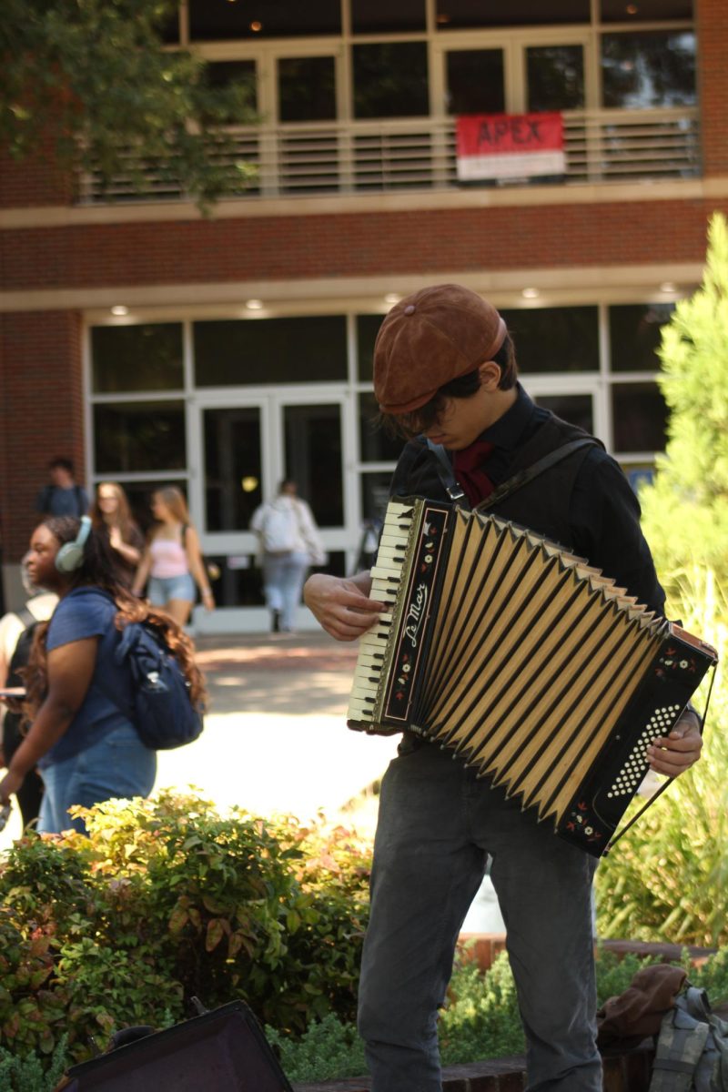 J.S. Bertoni plays accordion as students pass by for their first day of classes near the Woodward Library on Aug. 26, 2025.