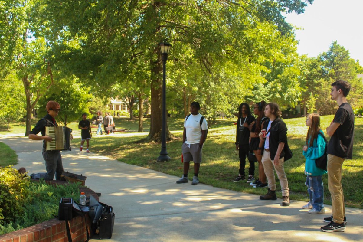 J.S. Bertoni attracts a small crowd as he plays "The Howls Moving Castle Theme" near the Woodward Library on Aug. 26, 2025.
