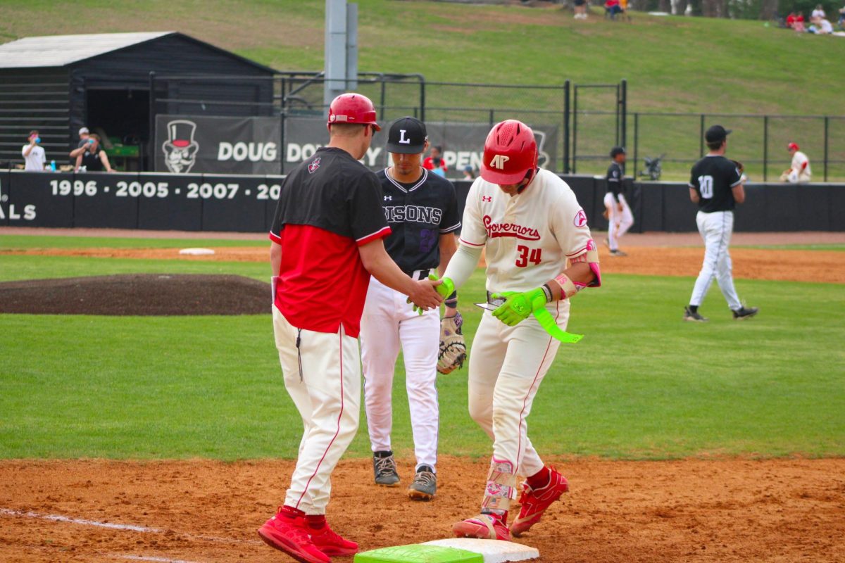 Austin Peay State University redshirt junior Cole Johnson celebrates his base hit with assistant head coach Jon Littell during a 12-8 victory over Lipscomb University on Saturday, March 21, at Raymond C. Hand Park.