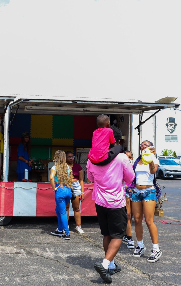 A family celebrates winning a prize during the Springtacular carnival, Saturday, April 11, at the Fortera Stadium parking lot, hosted by the Office of Student Life and Engagement and the Student Government Association.