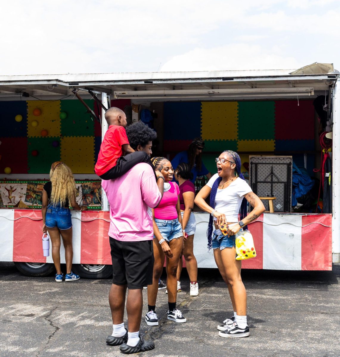A family celebrates winning a prize during the Springtacular carnival, Saturday, April 11, at the Fortera Stadium parking lot, hosted by the Office of Student Life and Engagement and the Student Government Association.