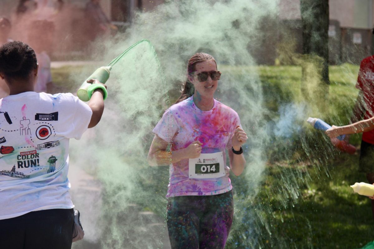 Austin Peay State University student runs through the powder thrown at her during the color run, Sunday afternoon, April 19, 2026.