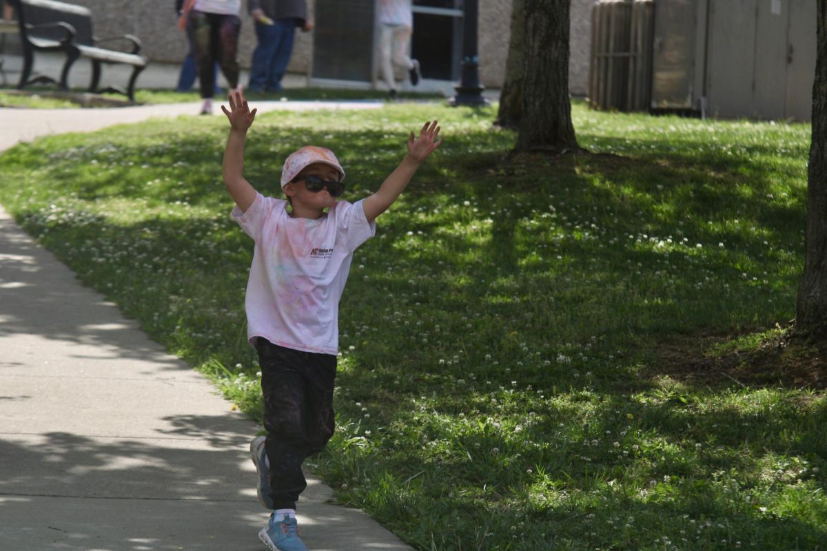 Local kid throws his hand up in celebration after finishing the color run, Sunday afternoon, April 19, 2026.